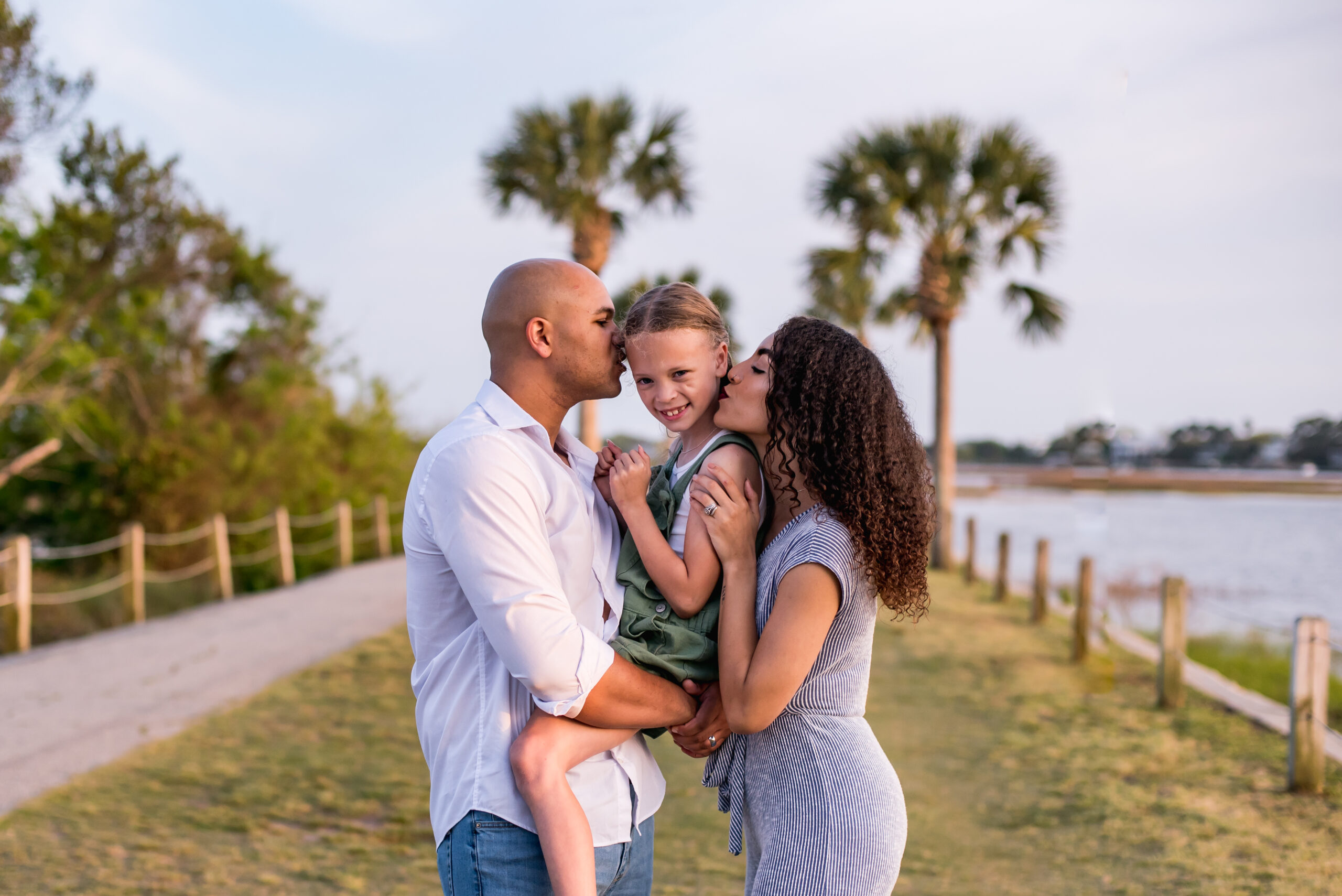 Family photo of mother, father and daughter at Pitt street bridge in mount pleasant, sc